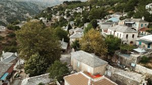 Traditional stone houses nestled on a green hillside.