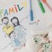 A child's colorful family drawing next to pens and a plush toy on a white surface.